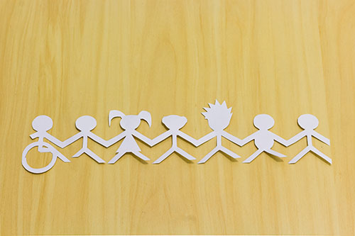 A paper cut-out shows a row of seven children holding hands. The first child is in a wheelchair.